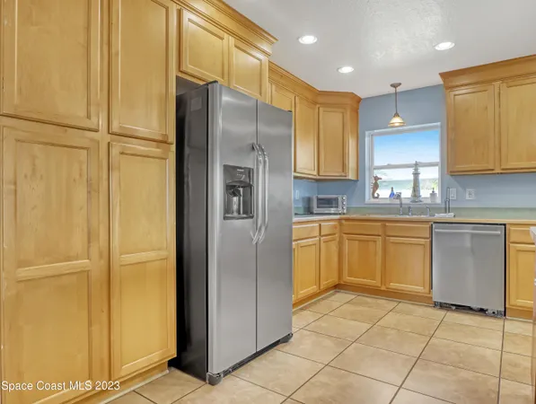 a kitchen with a refrigerator sink and cabinets