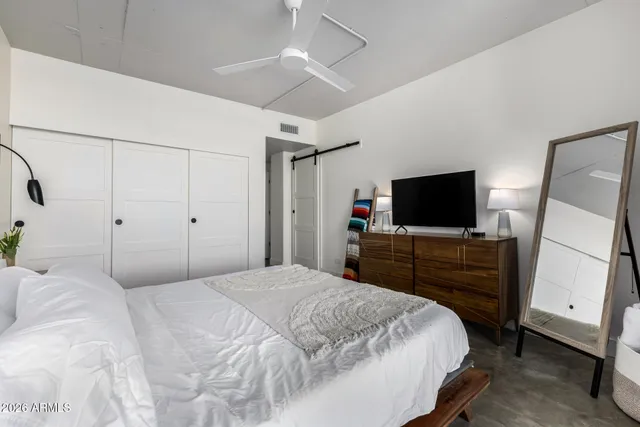 a bedroom with a bed and a flat screen tv