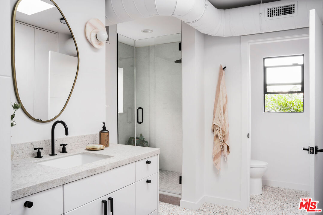 8550 Ridpath Drive Los Angeles, CA 90046 - Photo 21 of 32 a bathroom with a sink a toilet and a mirror