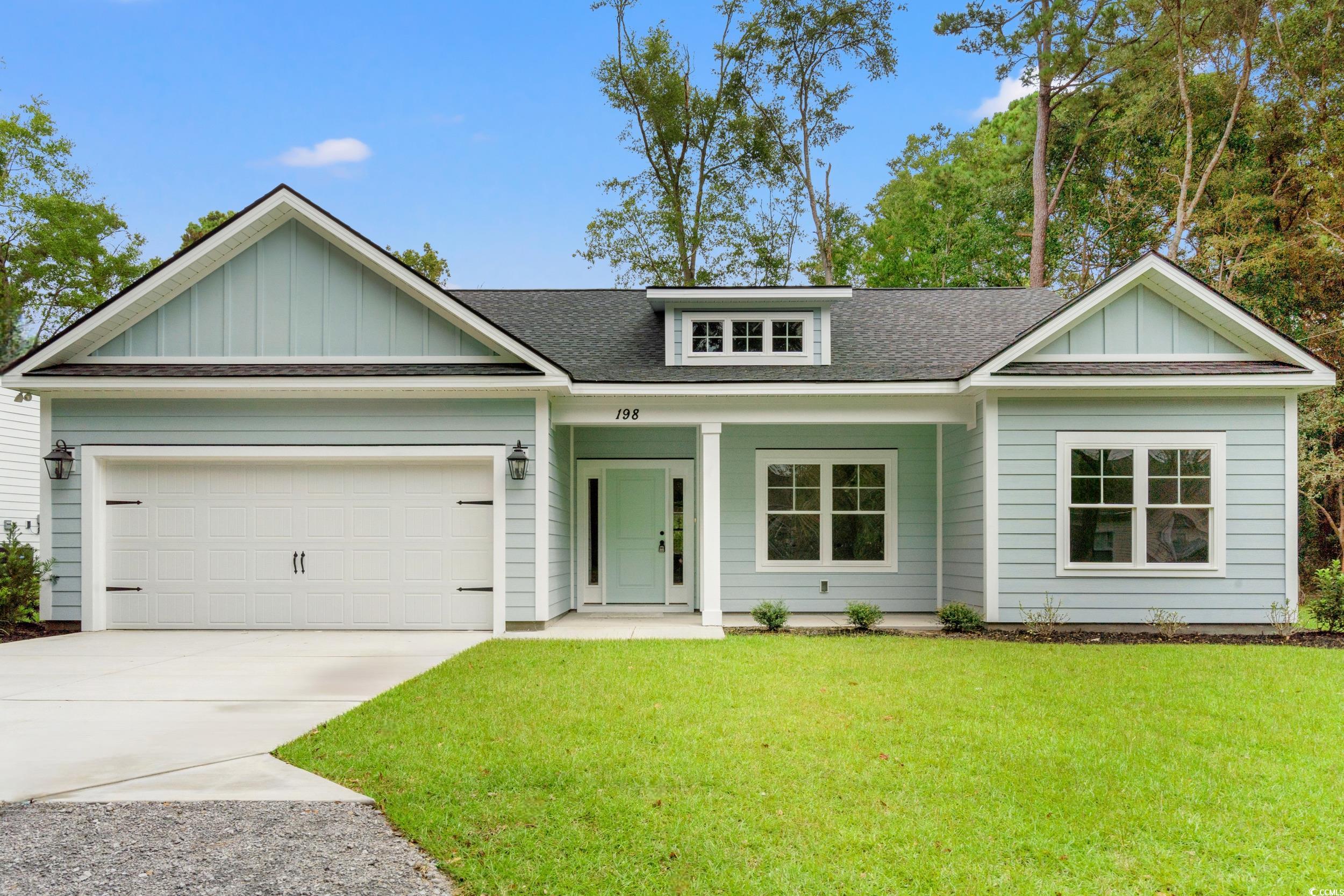 View of front of property with a shingled roof, a porch, board and batten siding, and a front lawn