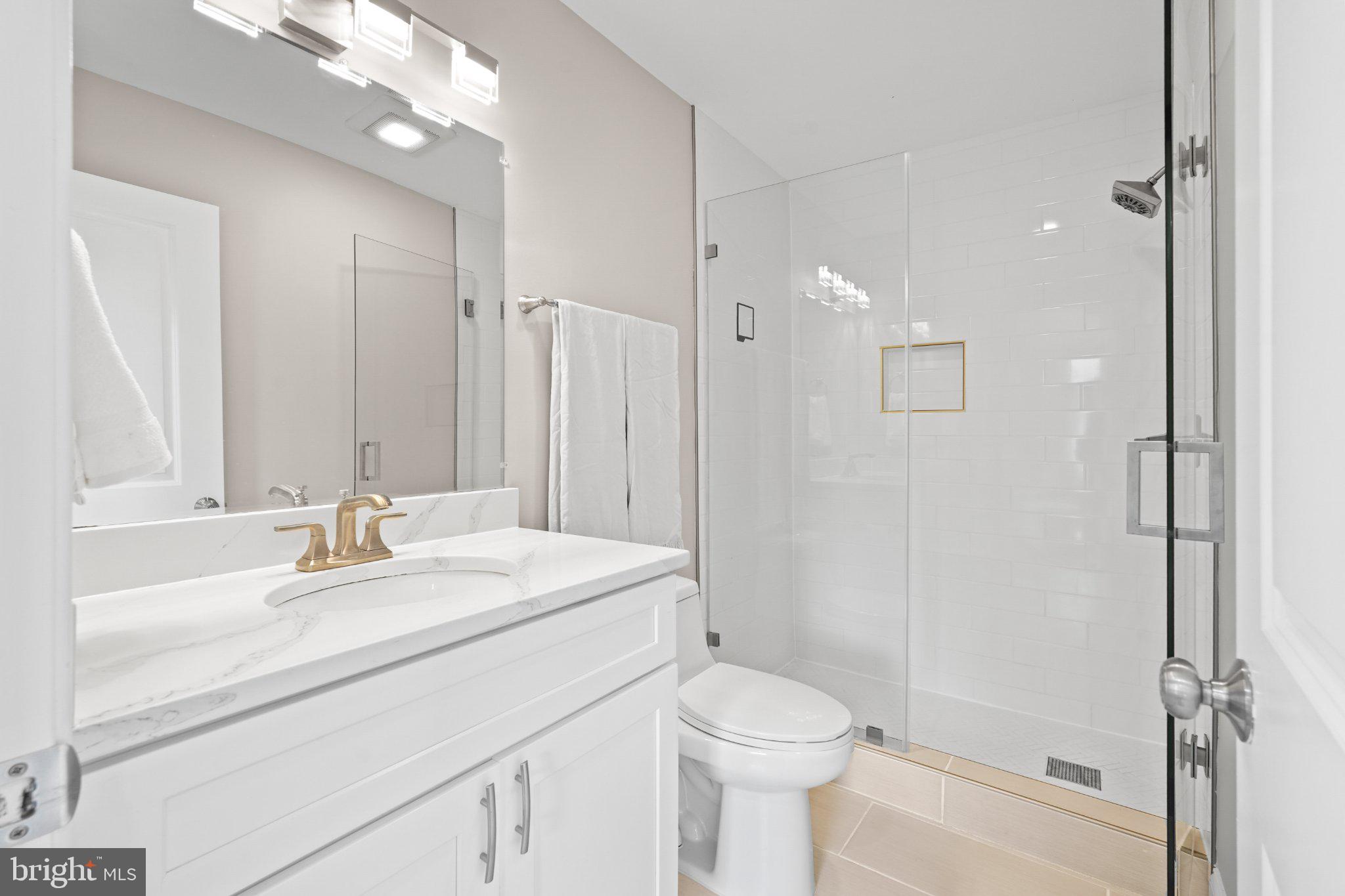 4416 Gault Place Northeast Washington, DC 20019 - Photo 18 of 30 a bathroom with a sink a toilet a large mirror and shower