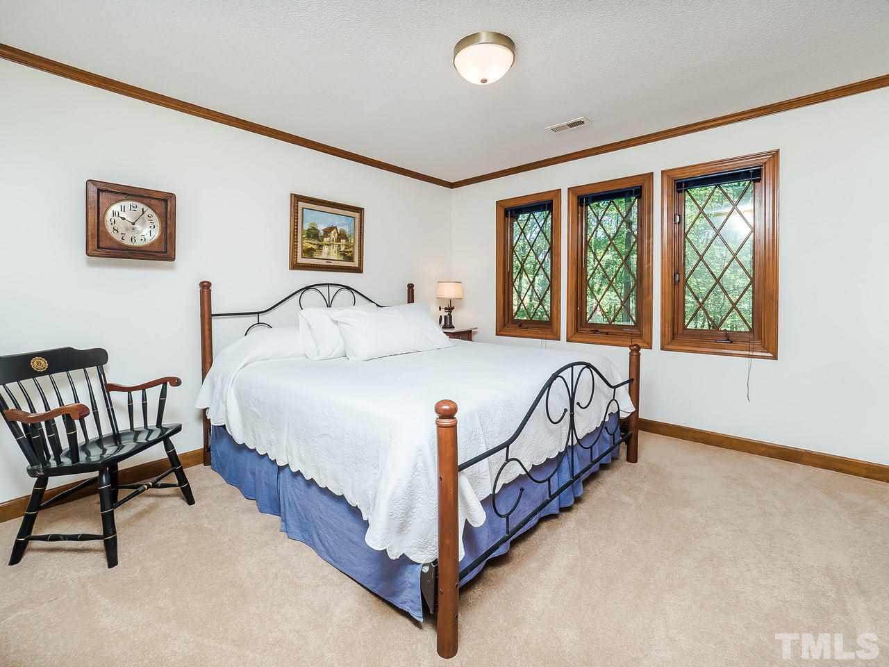 8857 Woodyhill Road Raleigh, NC 27613 - Photo 22 of 30 a bed sitting in a bedroom next to a window
