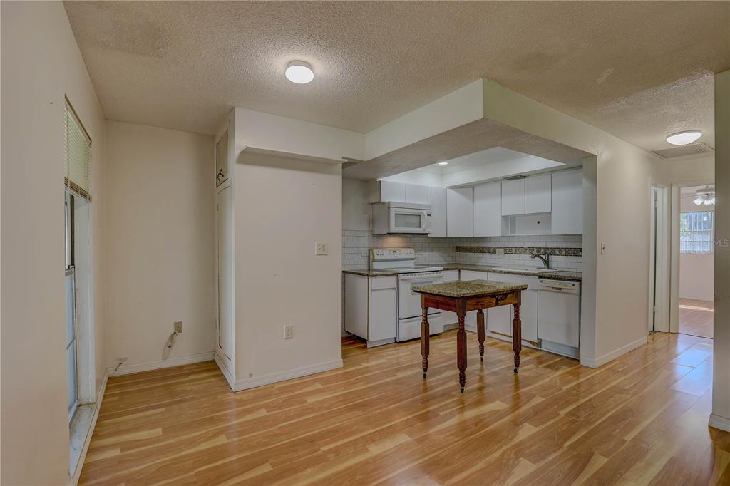 864 Lake Haven Road Dunedin, FL 34698 - Photo 7 of 28 a kitchen with stainless steel appliances granite countertop a stove a sink dishwasher and a refrigerator with wooden floor