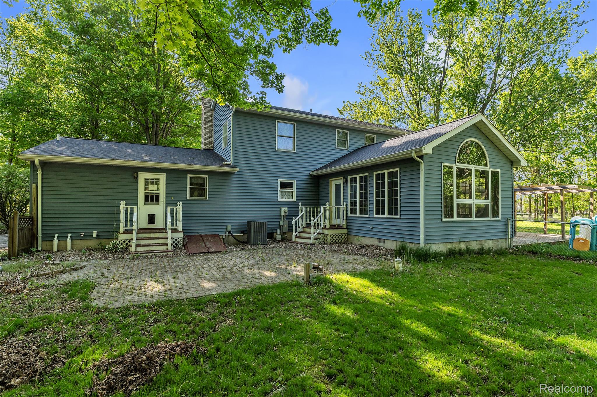 1345 Ives Road Mason, MI 48854 - Photo 58 of 92 Back of house featuring a lawn, a patio area, and a chimney