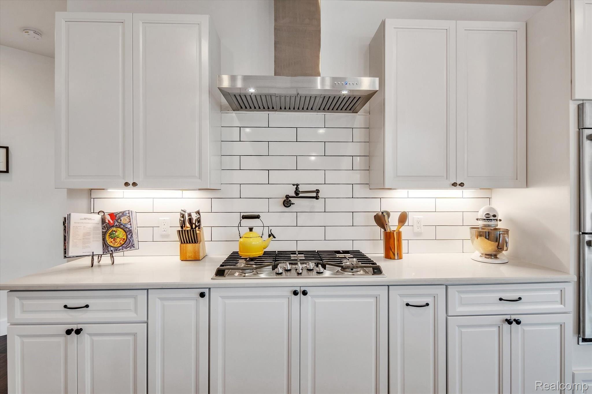 6100 Hartland Road Fenton, MI 48430 - Photo 16 of 67 Kitchen features custom island w/ farmhouse sink, walk-in pantry, full size fridge, full size freezer, double oven, quartz countertops, all stainless steel appliances and soft close cabinets.