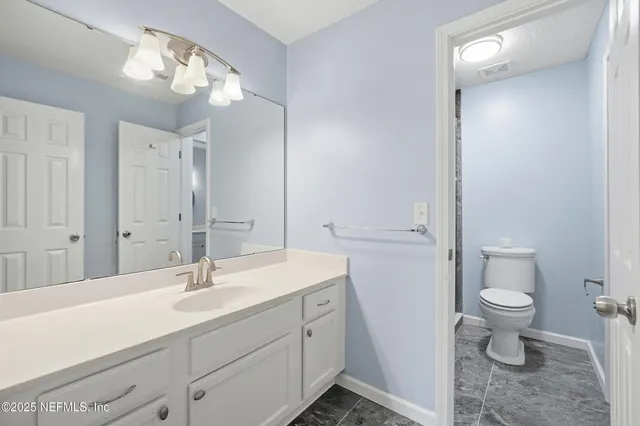 a bathroom with a sink a toilet and a mirror