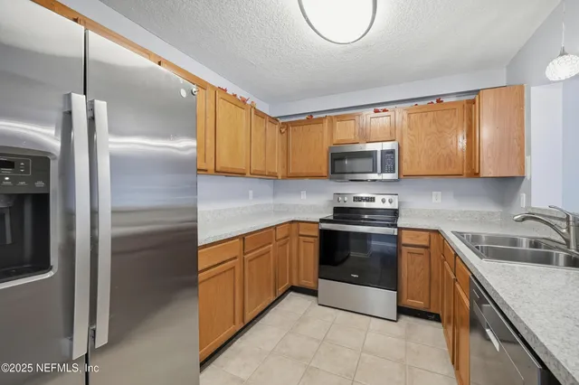 a kitchen with granite countertop a sink stainless steel appliances and cabinets