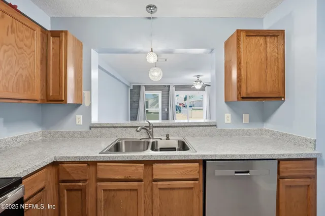 a kitchen with stainless steel appliances granite countertop a sink and dishwasher cabinets with wooden floor