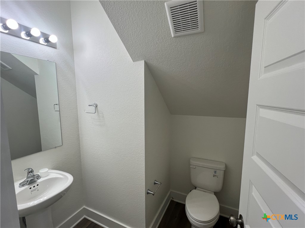 1826 Royal Loop Belton, TX 76513 - Photo 6 of 18 a white toilet sitting next to a bathroom sink