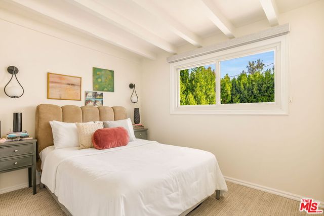 a living room with furniture a flat screen tv and floor to ceiling window