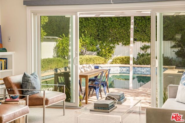 a patio with table and chairs and potted plants