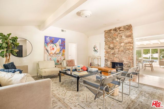 a living room with fireplace furniture and a potted plant