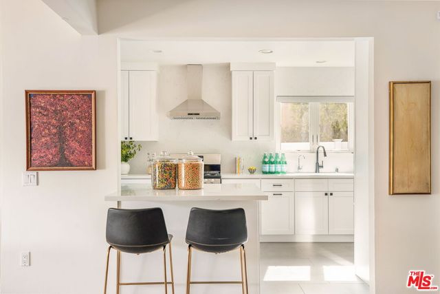a kitchen with granite countertop chair and white cabinets