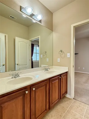a bathroom with a double vanity sink and a mirror