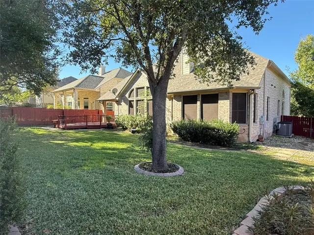 a front view of a house with a yard and tree