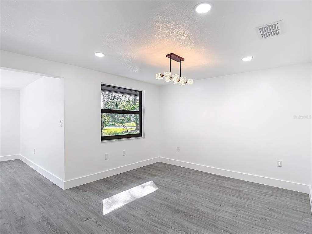 8130 San Felipe Court Port Richey, FL 34668 - Photo 13 of 54 wooden floor in an empty room with a window