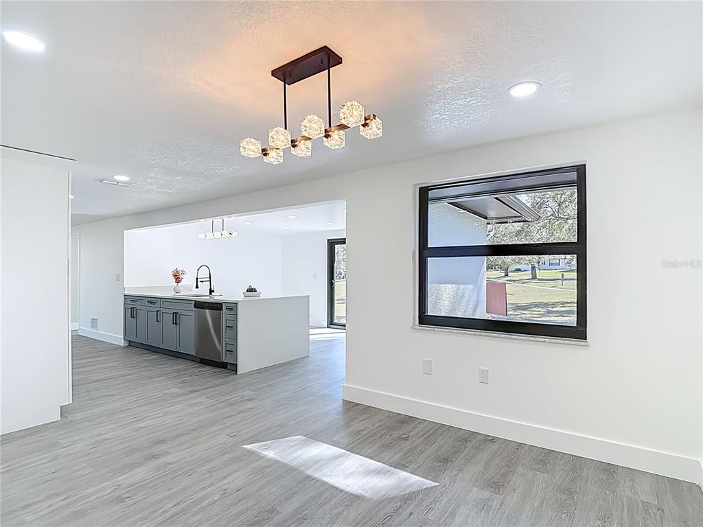 8130 San Felipe Court Port Richey, FL 34668 - Photo 14 of 54 a view of a living room and kitchen with furniture wooden floor and window