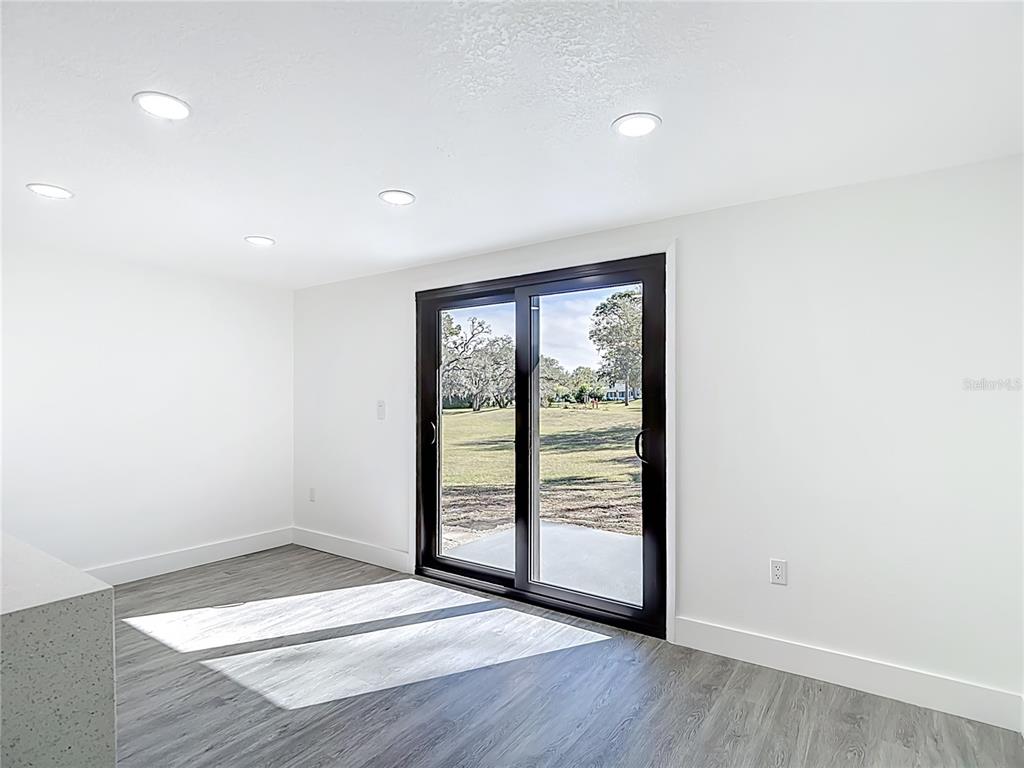8130 San Felipe Court Port Richey, FL 34668 - Photo 16 of 54 wooden floor in an empty room with a window
