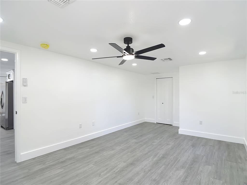 8130 San Felipe Court Port Richey, FL 34668 - Photo 23 of 54 an empty room with wooden floor and a ceiling fan