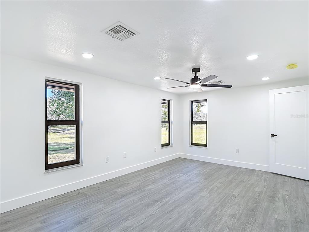 8130 San Felipe Court Port Richey, FL 34668 - Photo 25 of 54 an empty room with wooden floor and windows