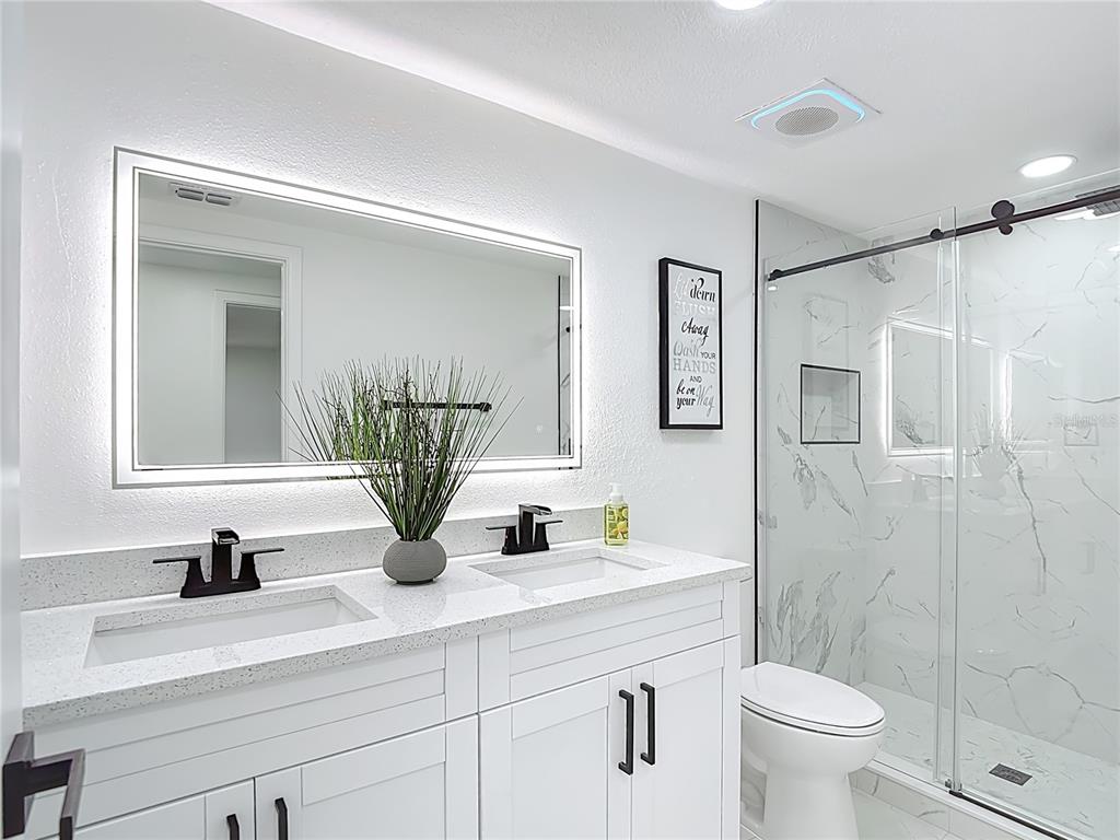 8130 San Felipe Court Port Richey, FL 34668 - Photo 38 of 54 a bathroom with a double vanity sink toilet and a mirror