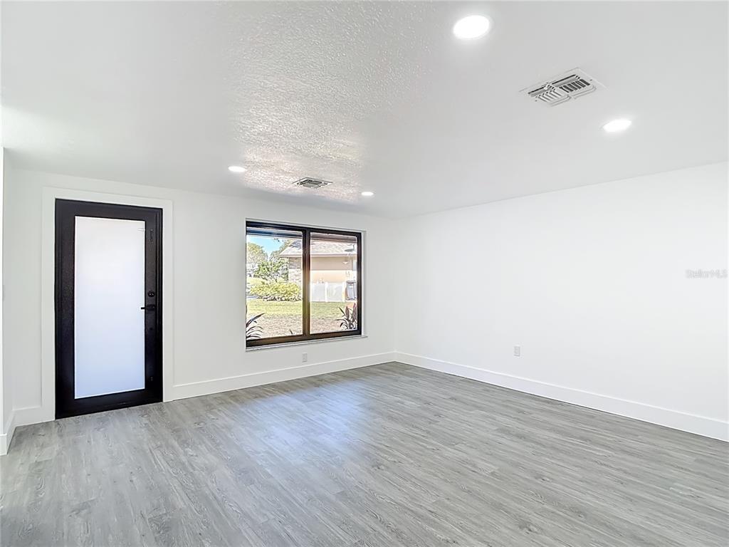 8130 San Felipe Court Port Richey, FL 34668 - Photo 4 of 54 an empty room with wooden floor and windows