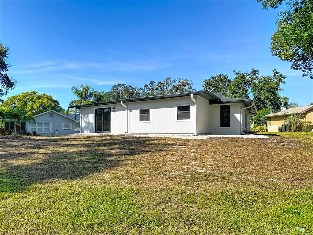 8130 San Felipe Court Port Richey, FL 34668 - Photo 48 of 54 a front view of house with yard and trees in the background
