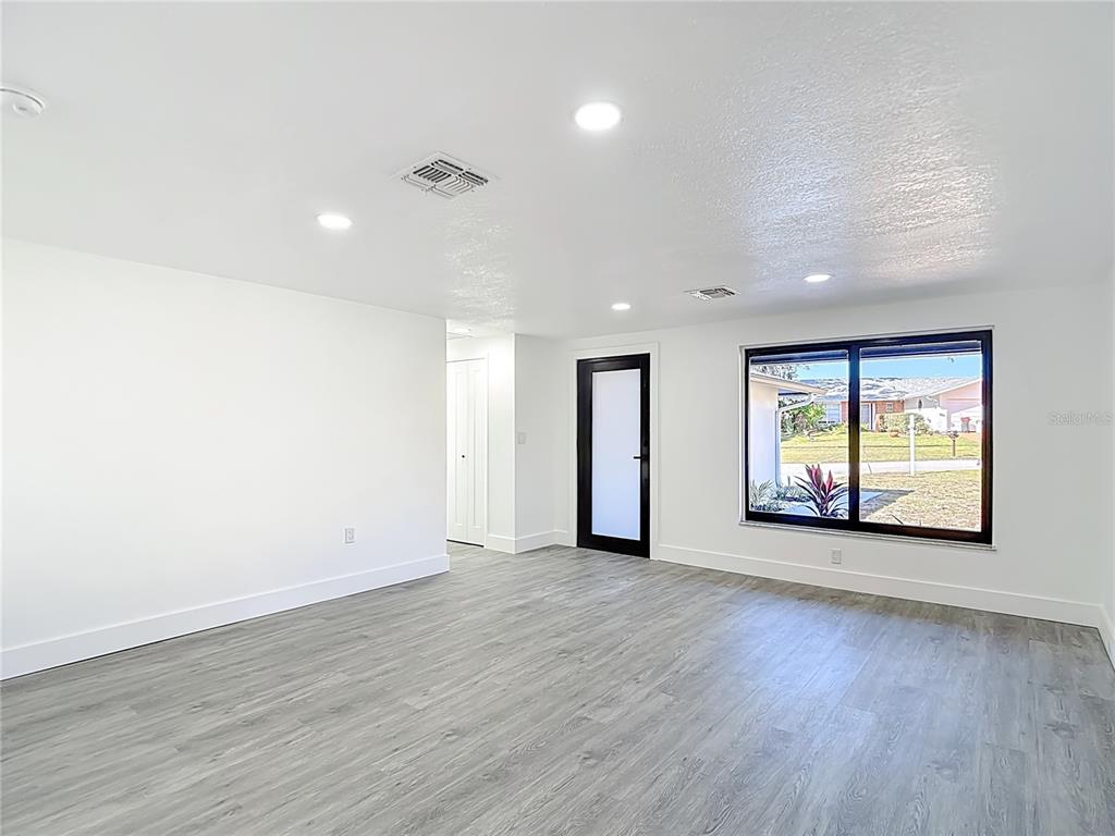 8130 San Felipe Court Port Richey, FL 34668 - Photo 5 of 54 an empty room with wooden floor and windows