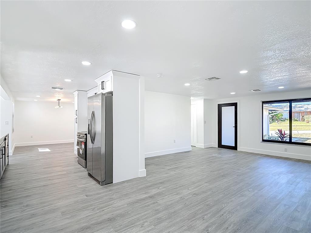 8130 San Felipe Court Port Richey, FL 34668 - Photo 6 of 54 a view of an empty room with wooden floor and a kitchen
