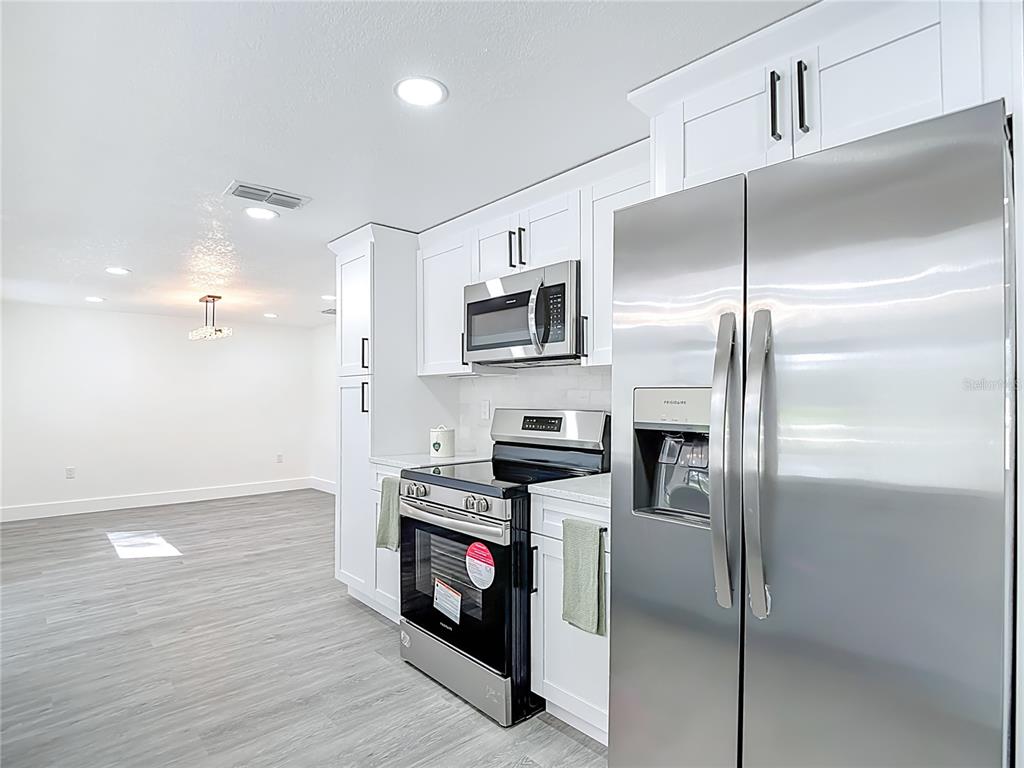 8130 San Felipe Court Port Richey, FL 34668 - Photo 8 of 54 a kitchen with stainless steel appliances granite countertop a refrigerator a stove and a sink