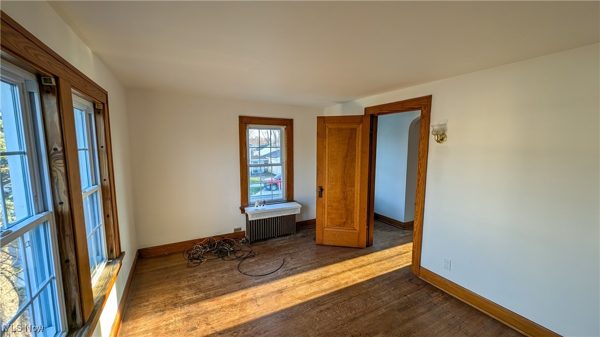 2511 Milan Road Sandusky, OH 44870 - Photo 28 of 40 Empty room with radiator and dark wood-type flooring