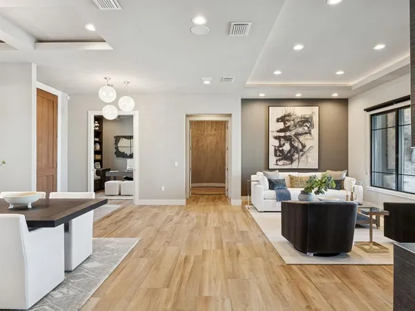 a view of a dining room and livingroom with furniture wooden floor a chandelier