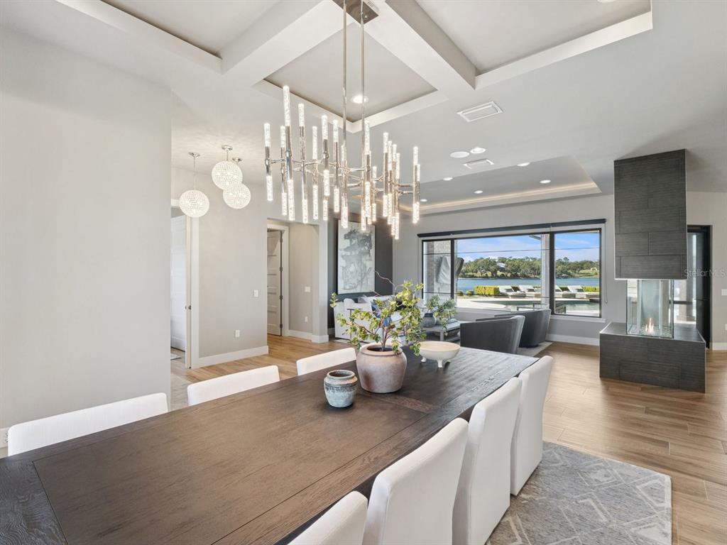 22151 Lake Seneca Road Eustis, FL 32736 - Photo 15 of 77 a view of a dining room and livingroom with furniture wooden floor a chandelier