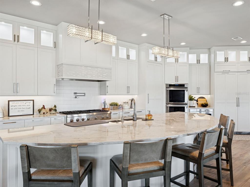 22151 Lake Seneca Road Eustis, FL 32736 - Photo 21 of 77 a kitchen with kitchen island granite countertop a table chairs sink and cabinets