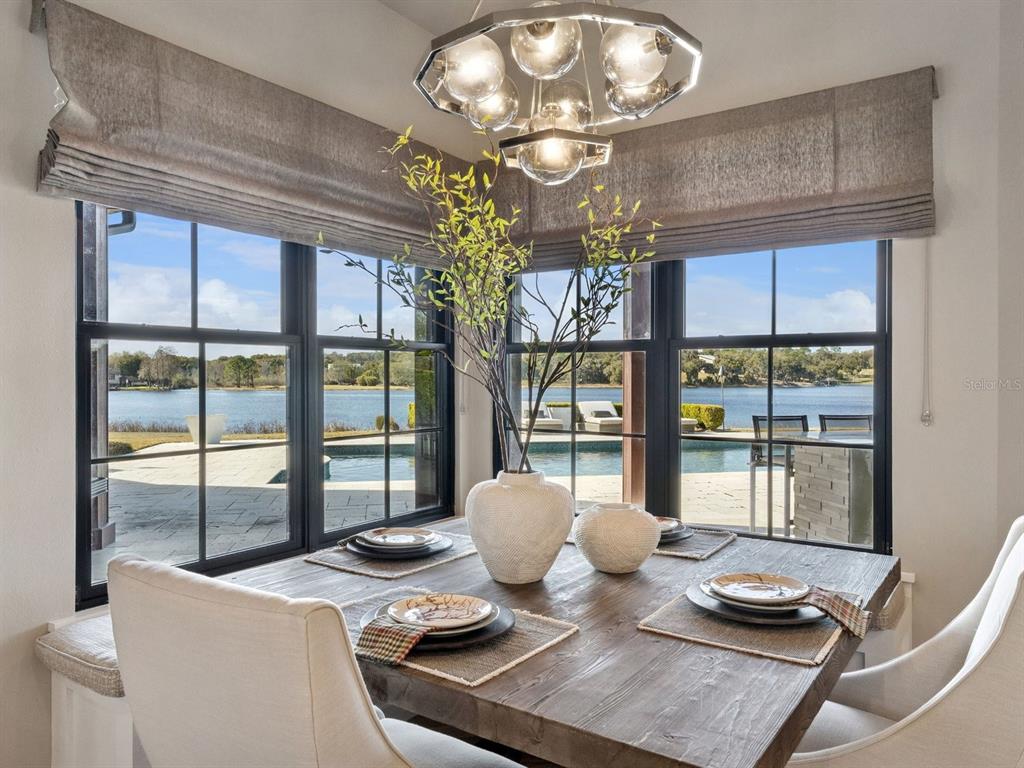 22151 Lake Seneca Road Eustis, FL 32736 - Photo 23 of 77 a view of a dining room with furniture a chandelier and large windows