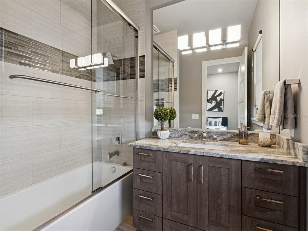 22151 Lake Seneca Road Eustis, FL 32736 - Photo 41 of 77 a bathroom with a granite countertop sink a mirror and shower