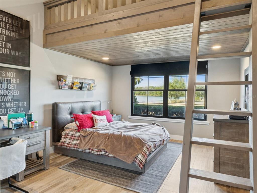 22151 Lake Seneca Road Eustis, FL 32736 - Photo 42 of 77 a bedroom with a bed and large window with balcony