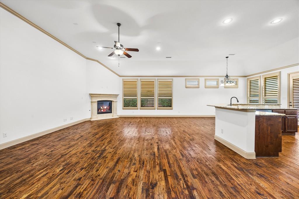 6814 Springwood Lane Garland, TX 75044 - Photo 13 of 35 a view of a kitchen with wooden floor and a ceiling fan