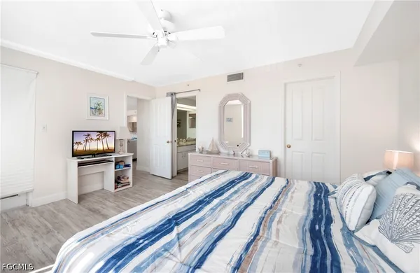 a bedroom with a bed and painting on the wall