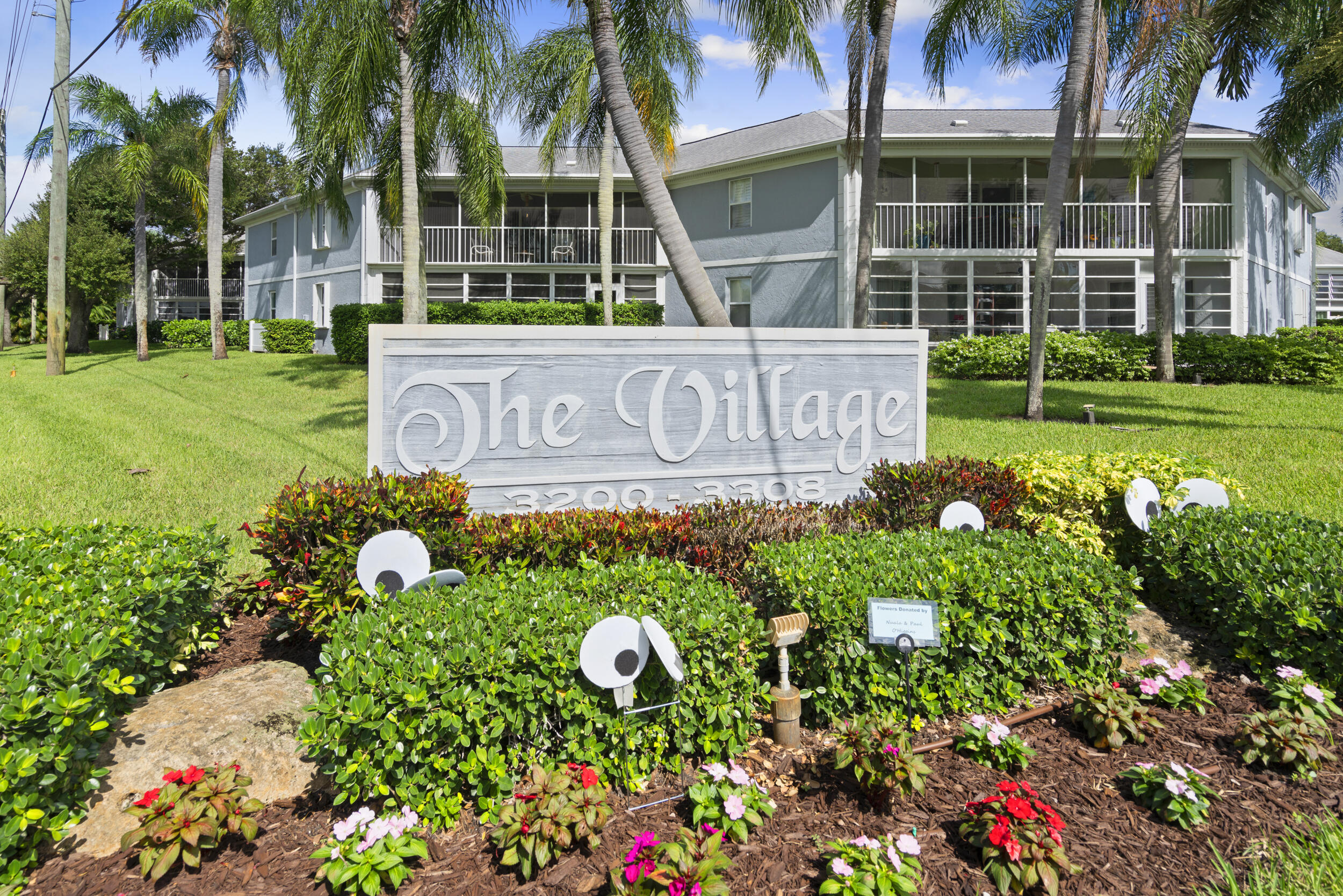 3278 Southeast Aster Lane, Unit F155 Stuart, FL 34994 - Photo 2 of 41 front view of a house with a yard and potted plants