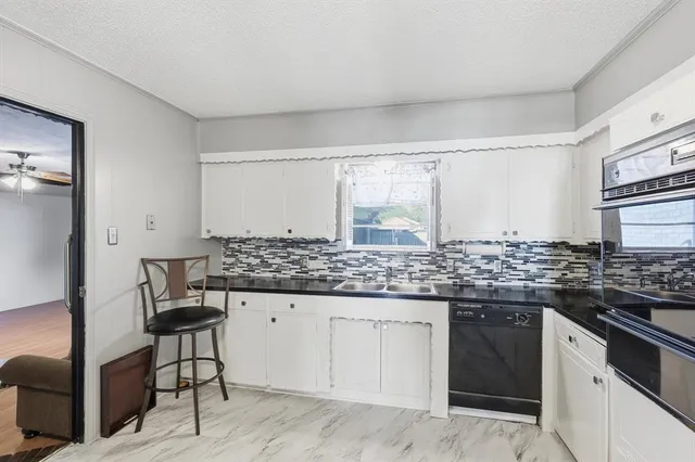a kitchen with granite countertop a sink and cabinets