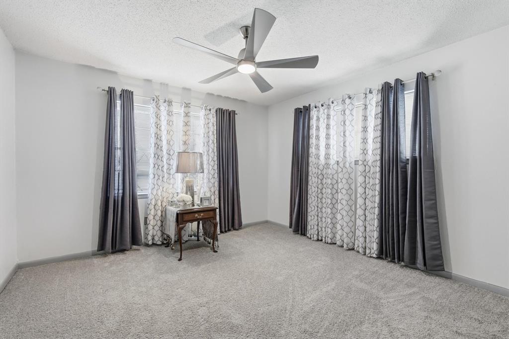 910 Rockwall Street McKinney, TX 75069 - Photo 19 of 34 Spare room featuring a textured ceiling, light carpet, and a ceiling fan