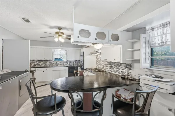 a kitchen with a table chairs stove and microwave