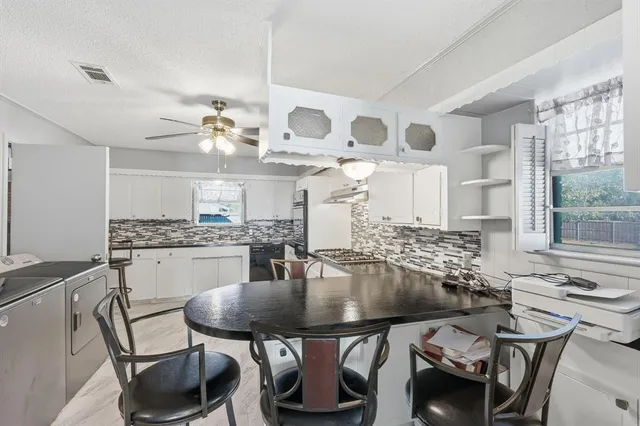 a kitchen with a table chairs stove and microwave