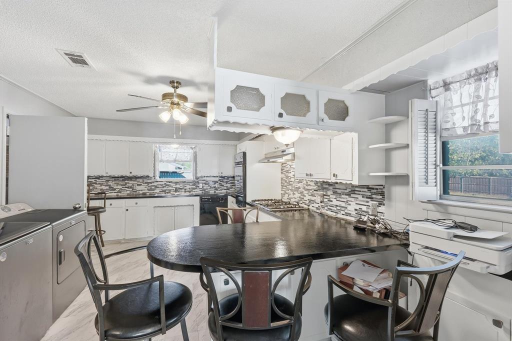 910 Rockwall Street McKinney, TX 75069 - Photo 9 of 34 Kitchen with a peninsula, white cabinetry, tasteful backsplash, open shelves, and washing machine and dryer