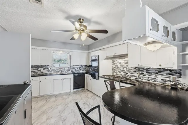 a kitchen with stainless steel appliances granite countertop a stove sink and cabinets