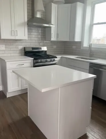 a kitchen with a sink a stove and cabinets
