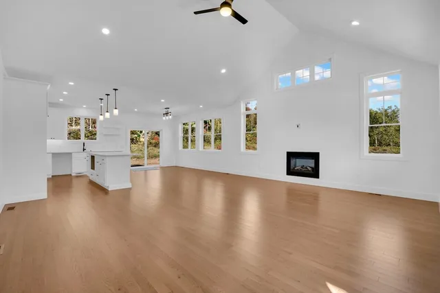 a view of an empty room with a kitchen and a window