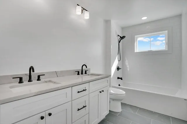 a bathroom with a granite countertop sink a toilet and a bathtub