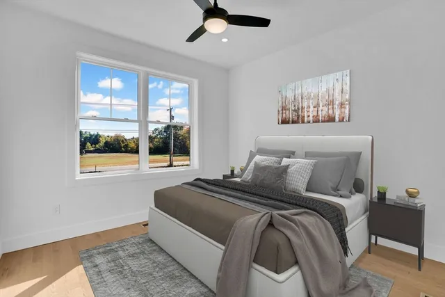 a bedroom with a bed and a large window